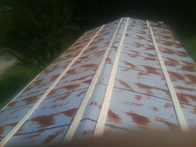 Rusted metal roof panels with new wood purlins before replacement — Storm Damage Roof Repair in Vandalia by Roofing Brothers