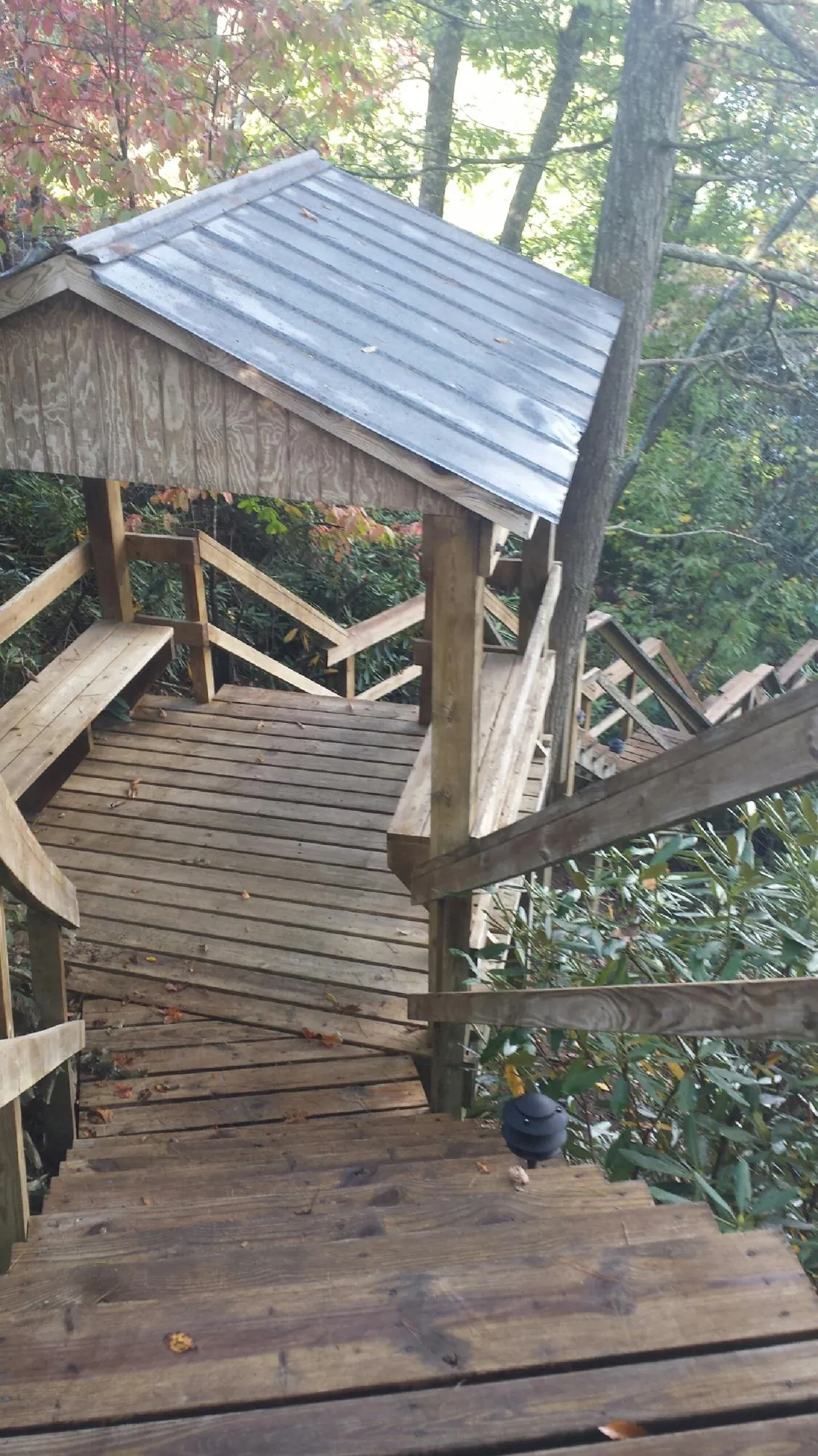 Metal roofed shelter over wooden steps on a wooded walkway — Skylight Repair & Installation work by our crew in Vandalia