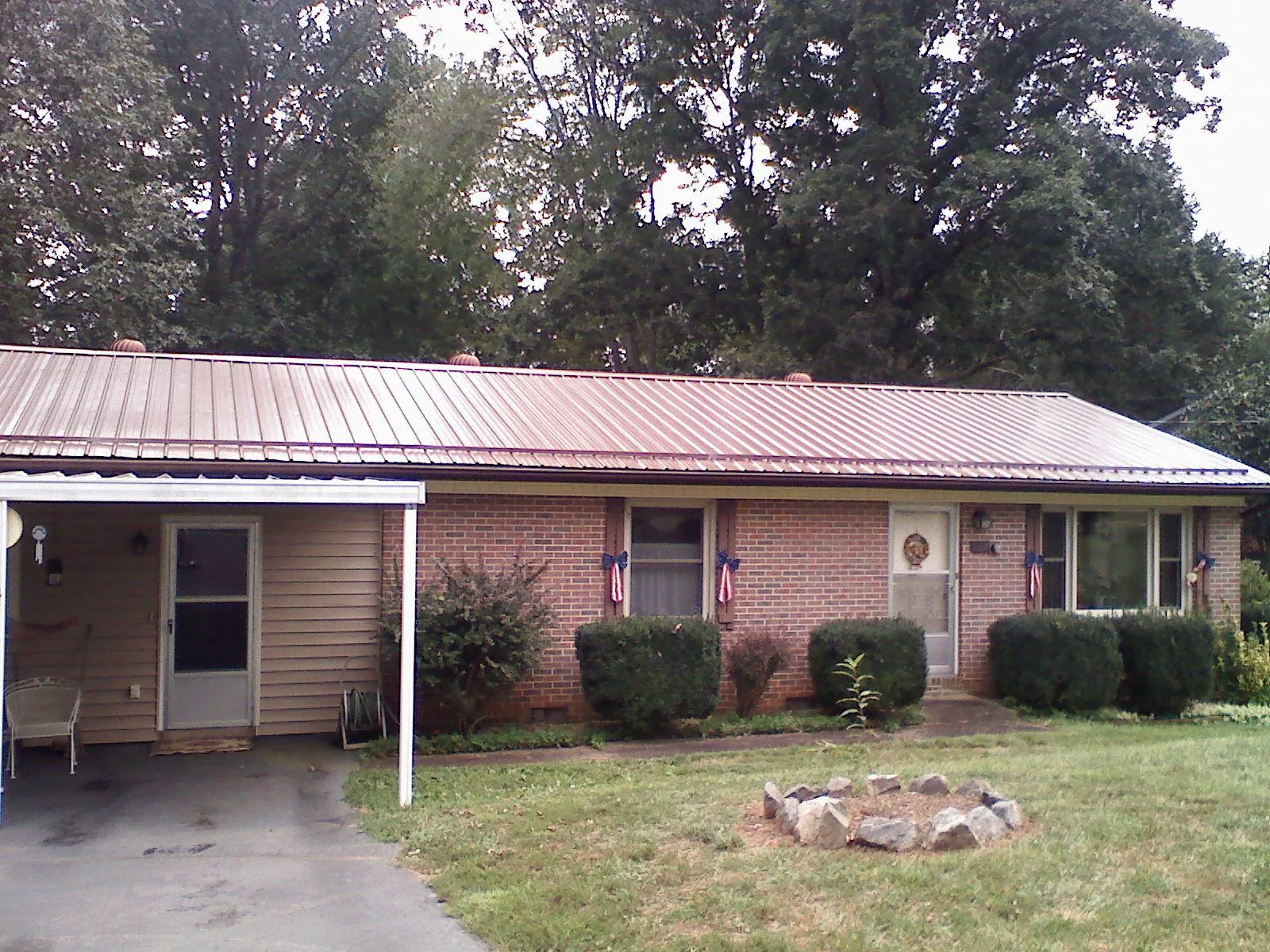 Bronze metal roof and carport on a brick ranch home — Roof Repair work by our crew in Vandalia